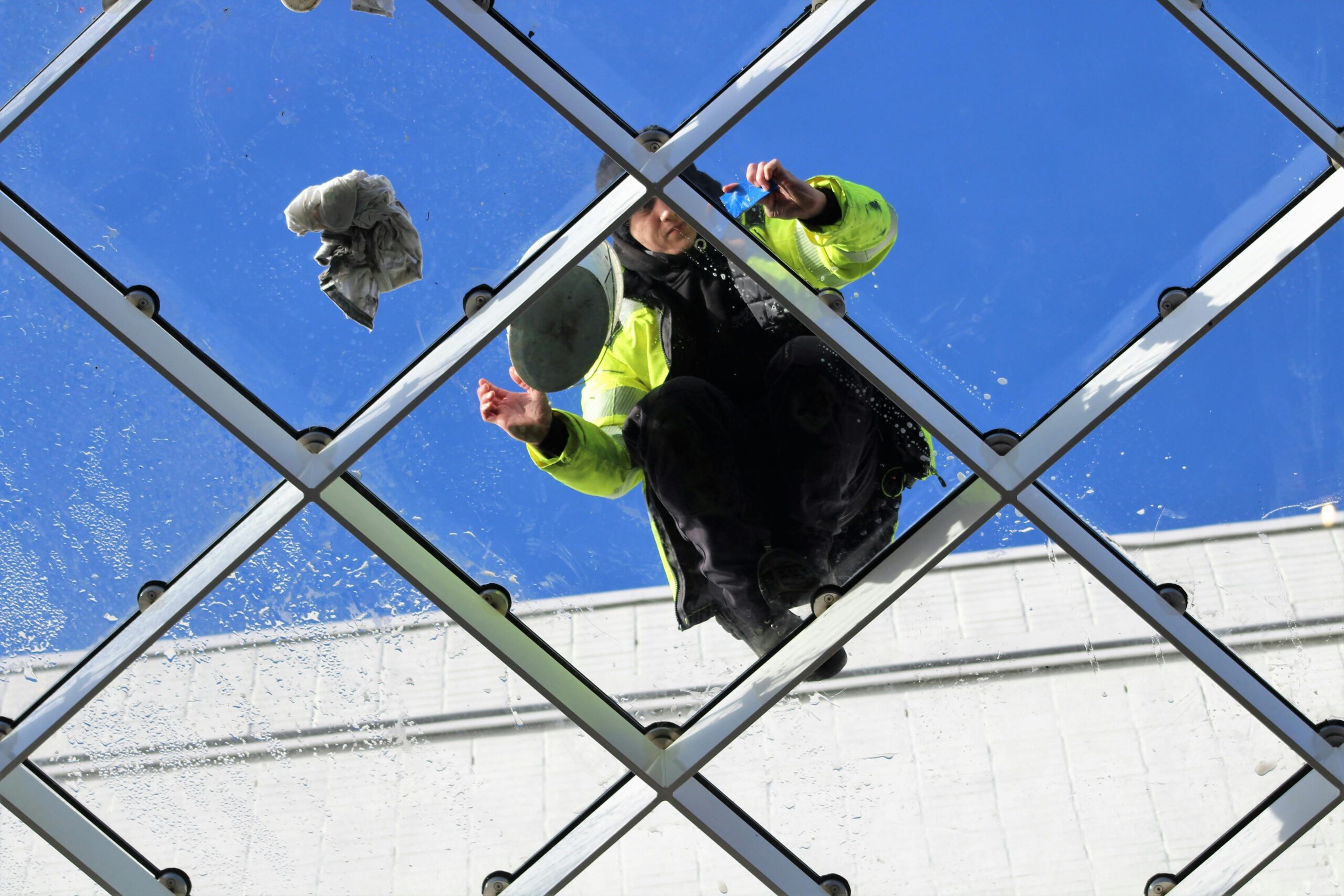 Technician installing a commercial glass canopy structure in Los Angeles