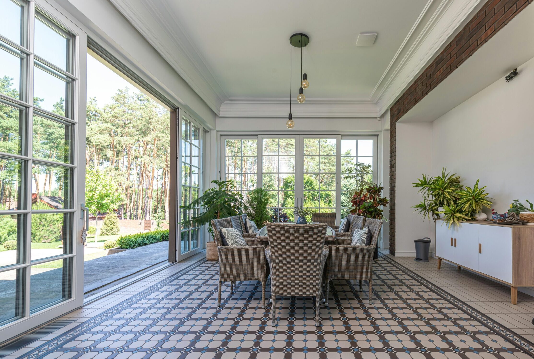 Bright modern sunroom with large French and sliding glass doors opening to a garden